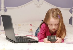 Girl using laptop and cell phone