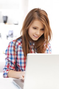 smiling student girl with laptop at school